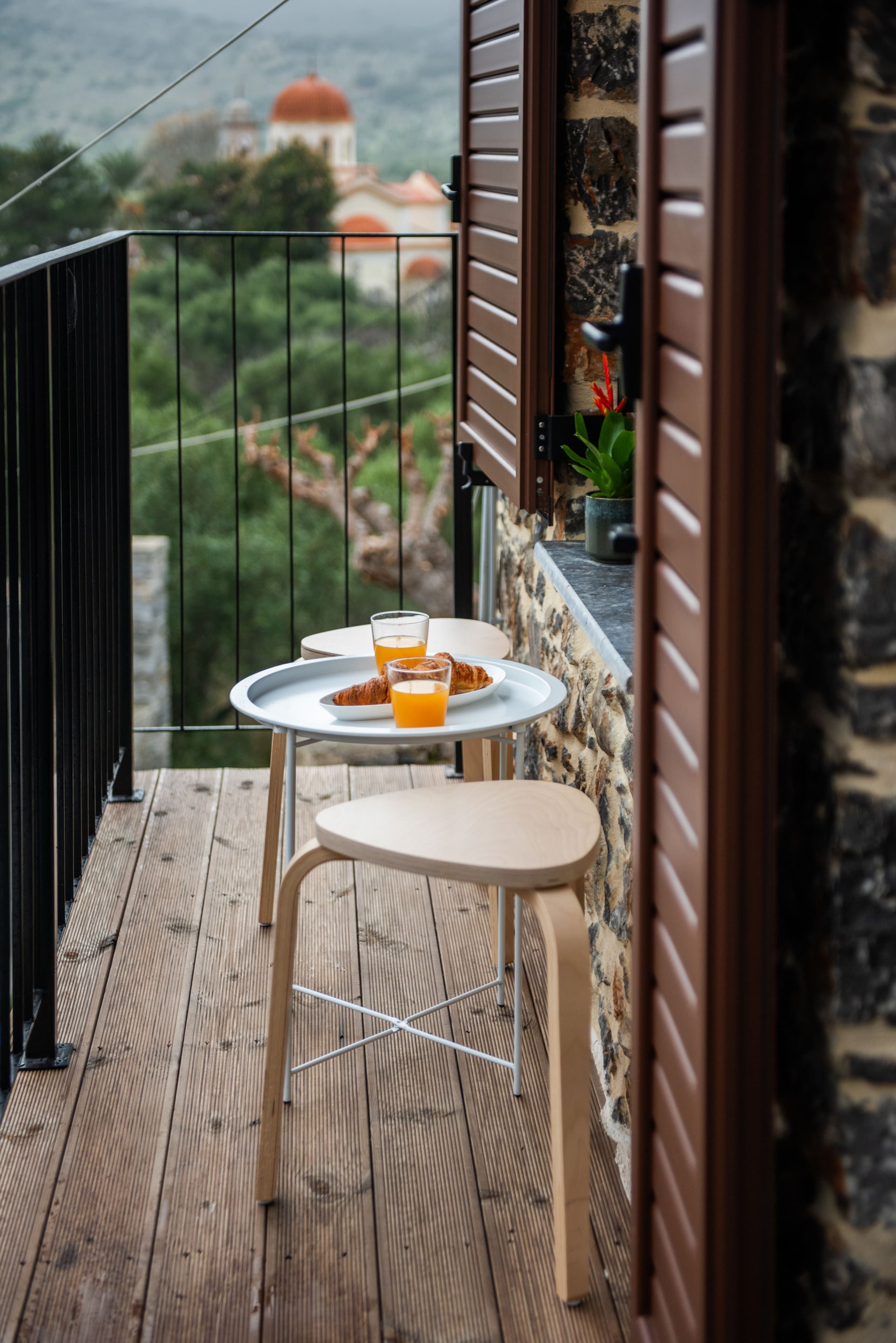 Narrow balcony with a table, above the village roofs