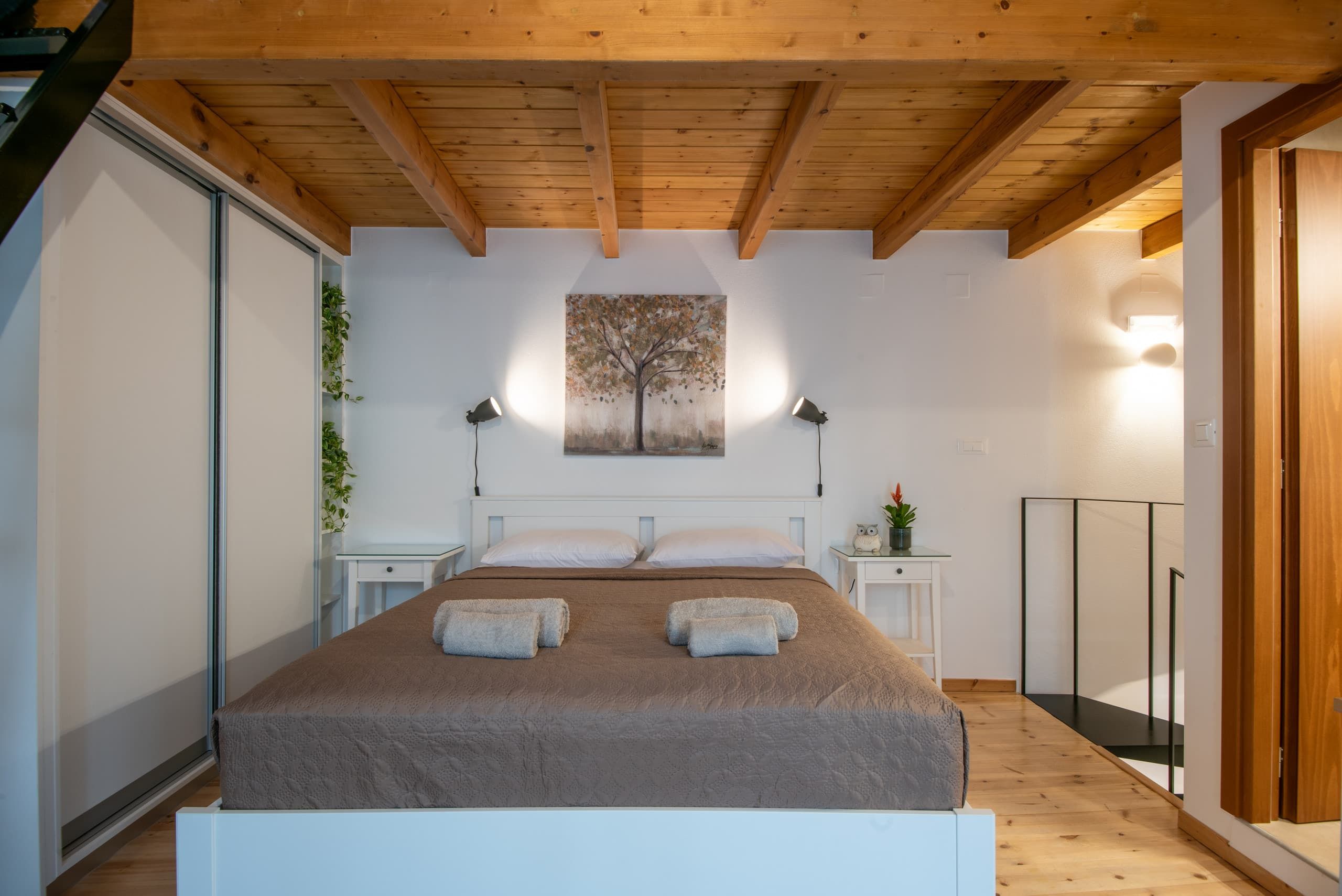 Double bed under the beams, glass railing