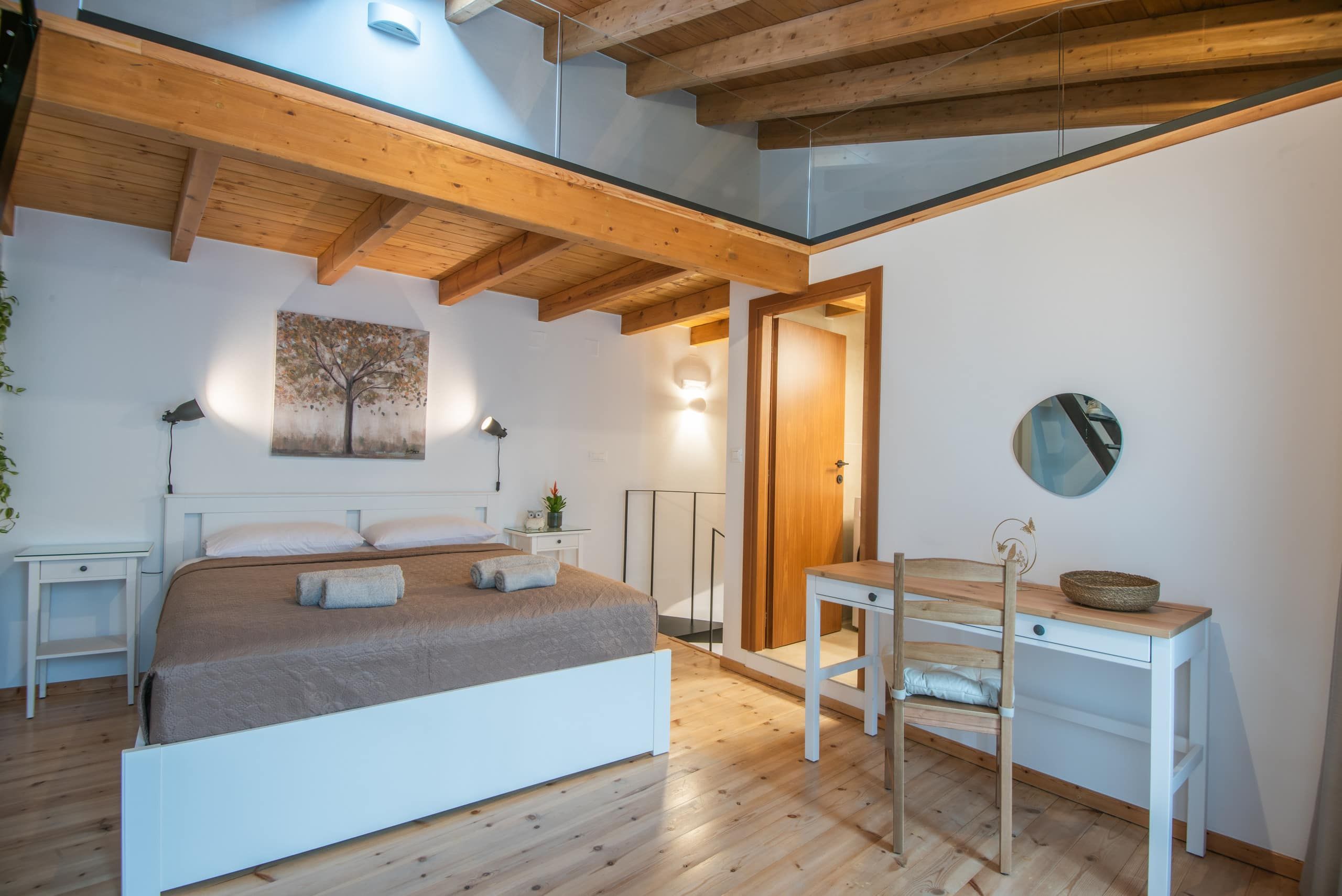 Bedroom with double bed, desk and round mirror