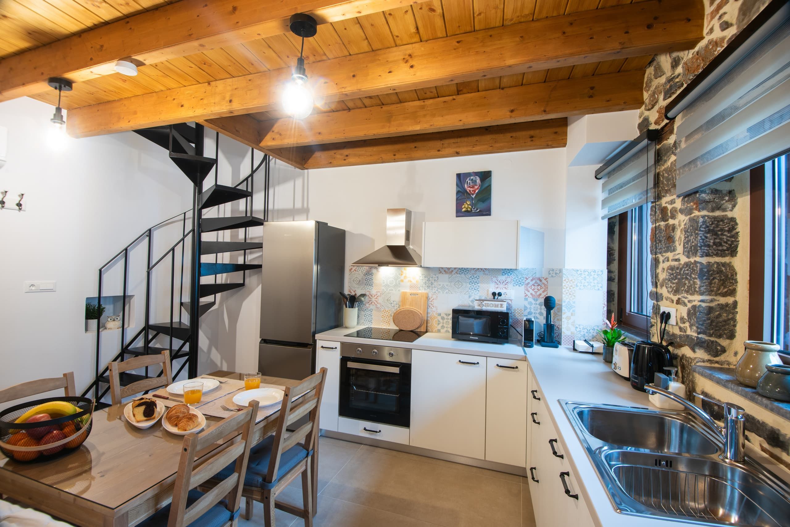 Equipped kitchen, table and black spiral staircase