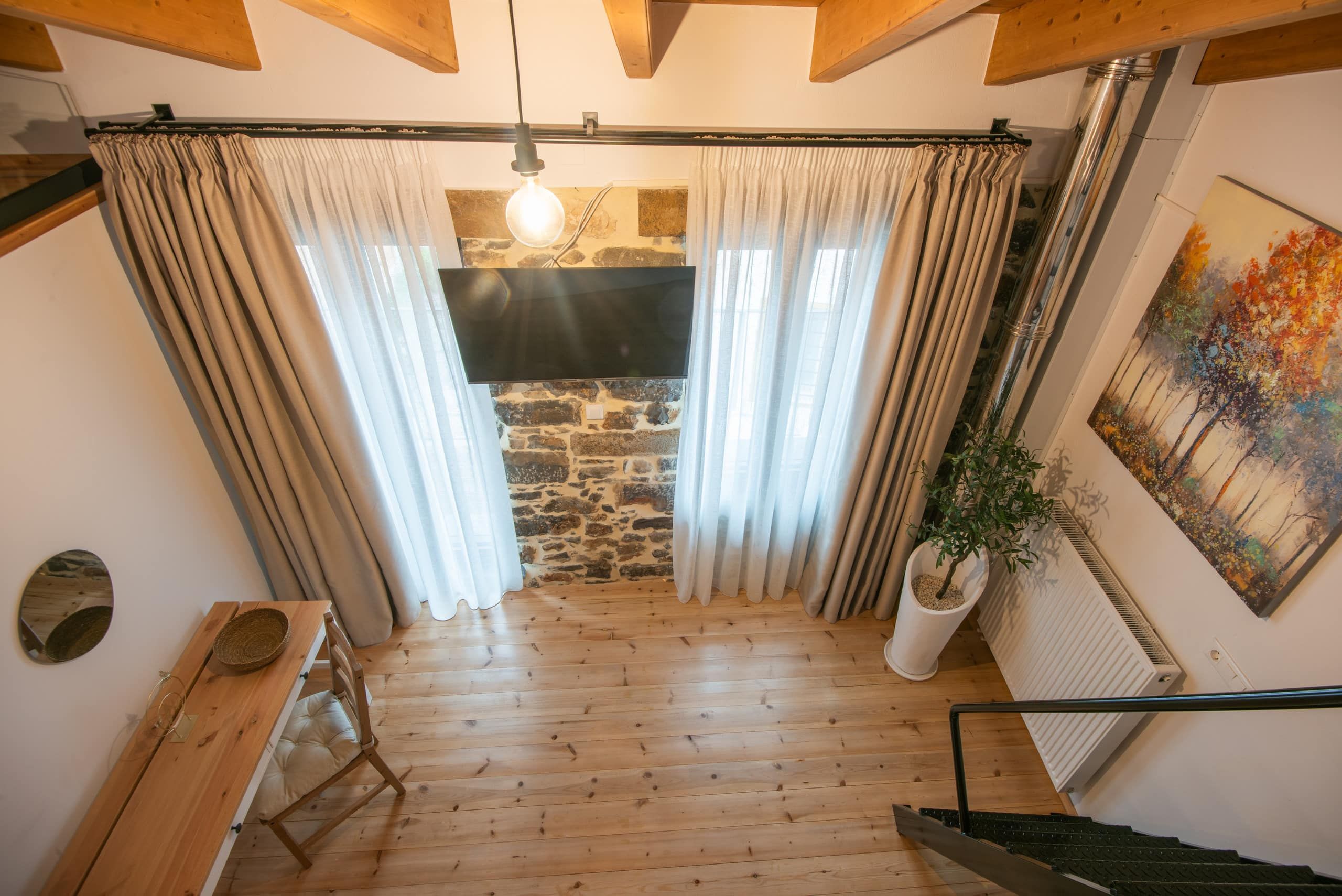 Upstairs room: curtains, stone wall, wooden bench